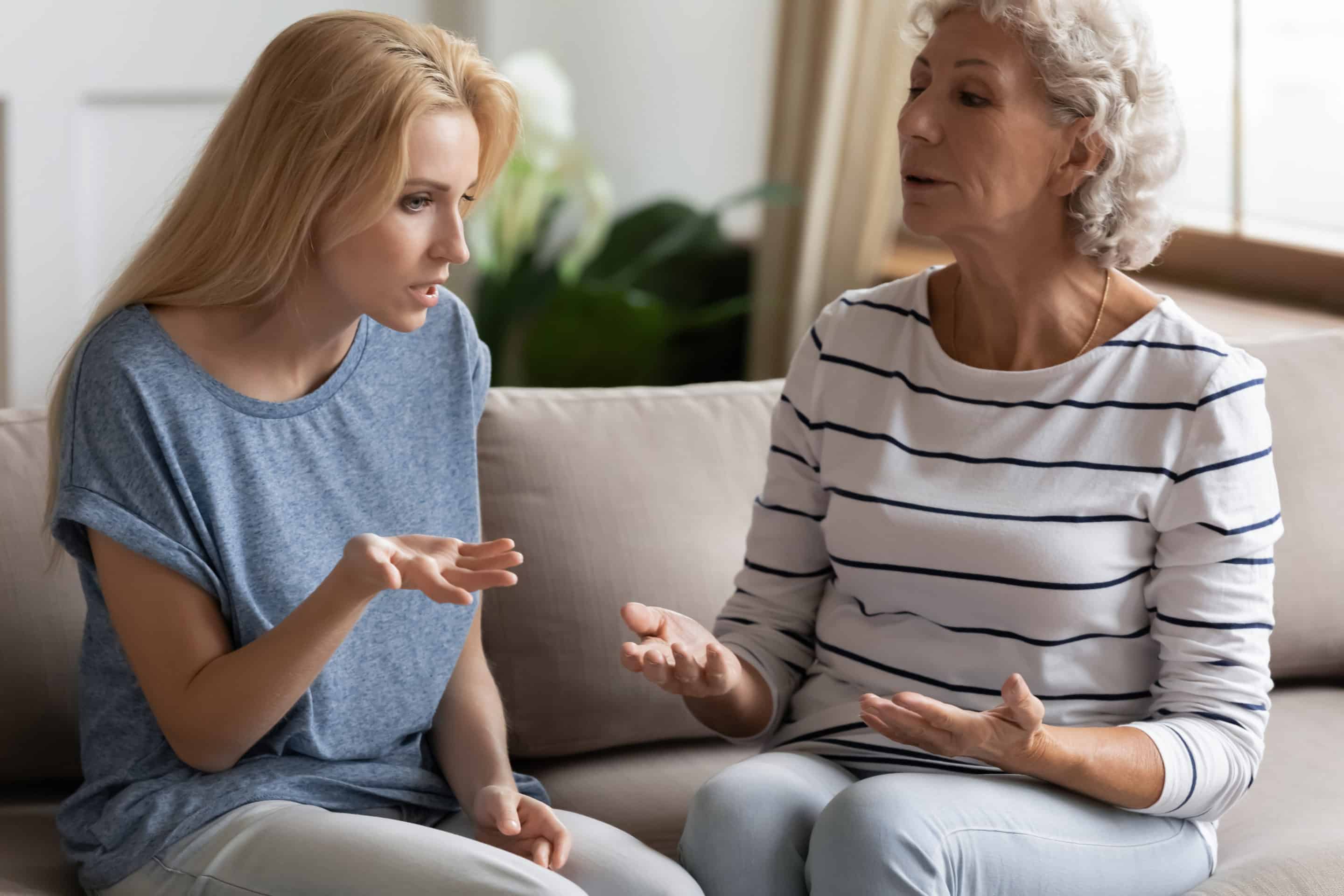 Jeune femme frustrée discutant avec sa mère, incarnant le conflit dans une relation avec une mère perverse narcissique.