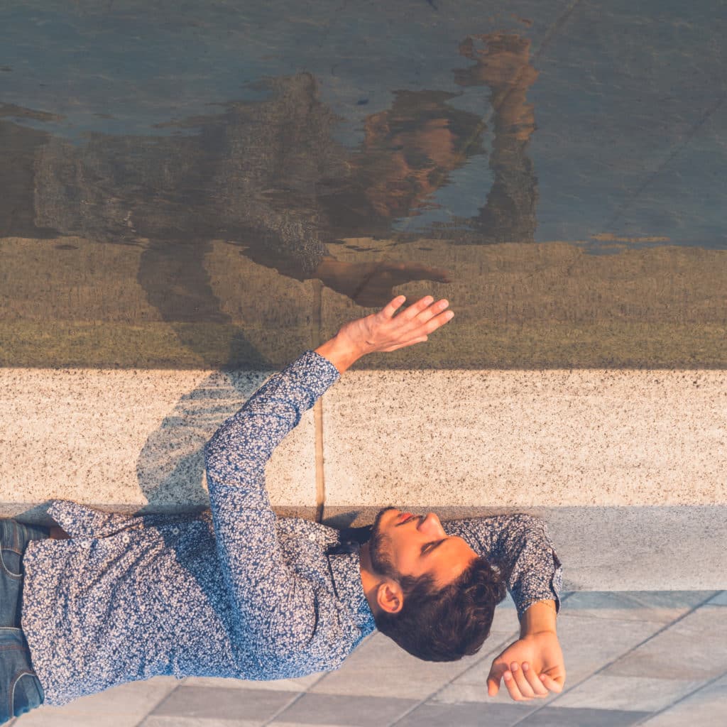 Réflexion d’un homme dans l’eau, représentant le lien entre le mythe de Narcisse et le narcissisme pathologique.