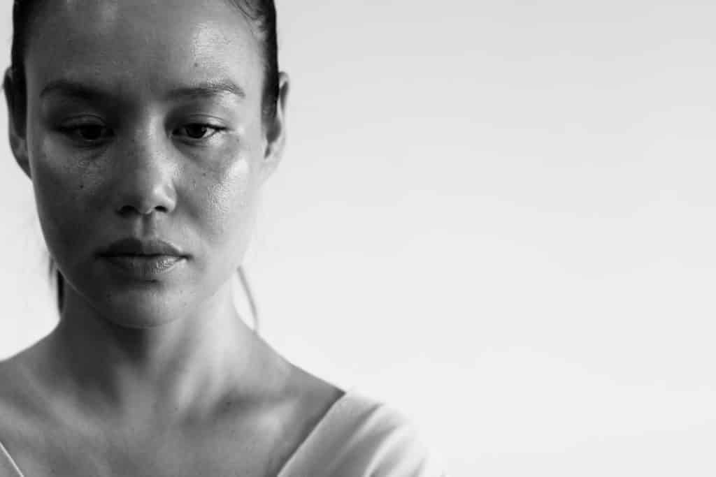 Image en noir et blanc d’une femme pensive, évoquant les séquelles traumatiques d’une relation toxique.