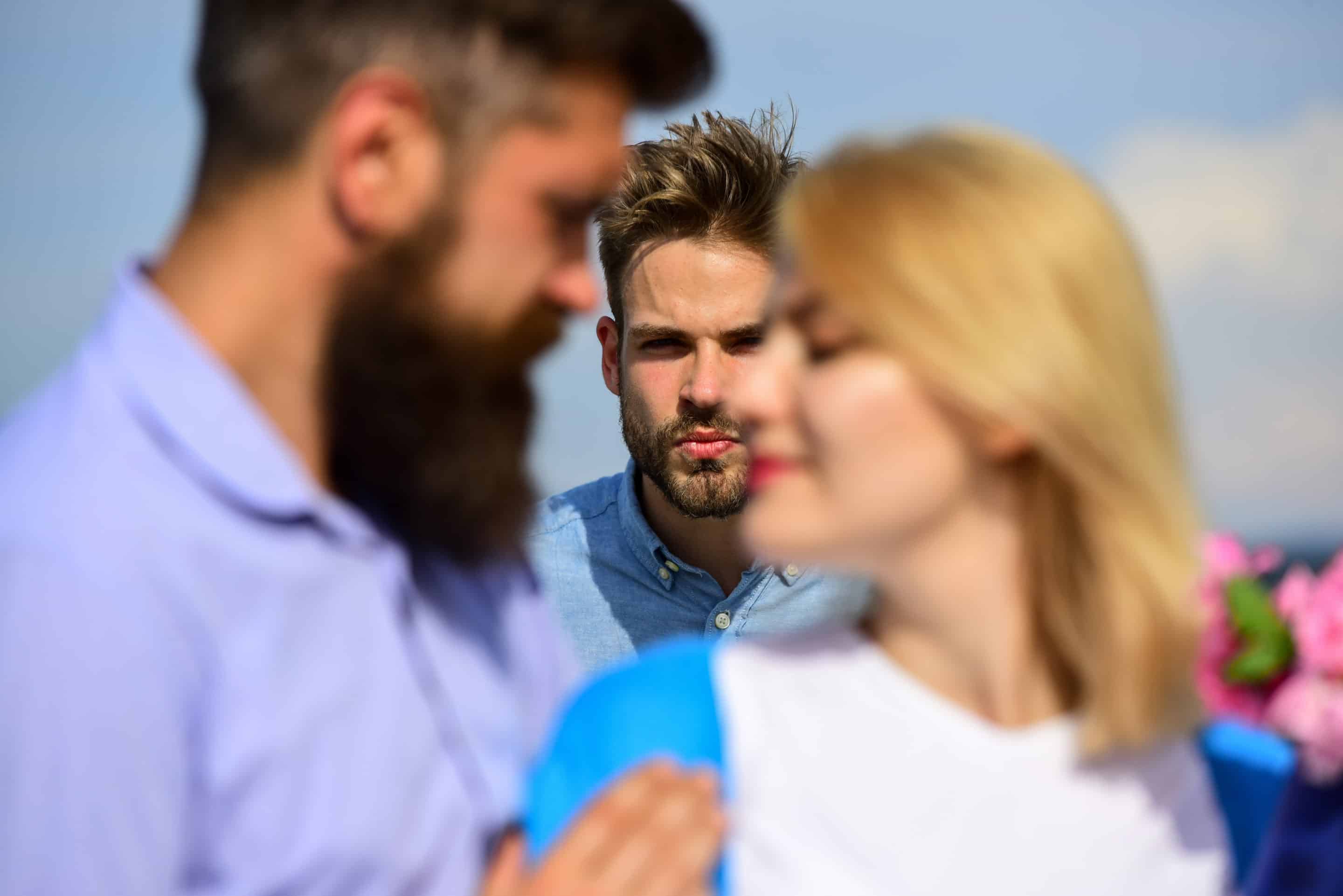 Scène avec un homme focalisé sur un couple, évoquant la jalousie et l’obsession typiques du pervers narcissique envers son ex.
