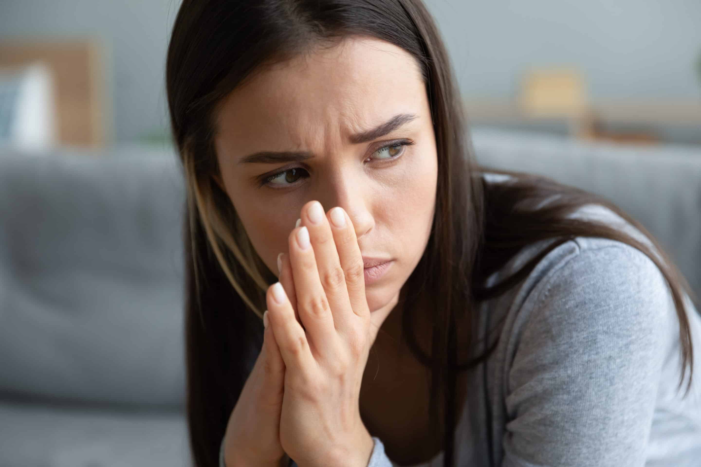 Visage d’une femme absorbée par ses pensées, évoquant l’importance de surmonter les blocages émotionnels pour avancer.