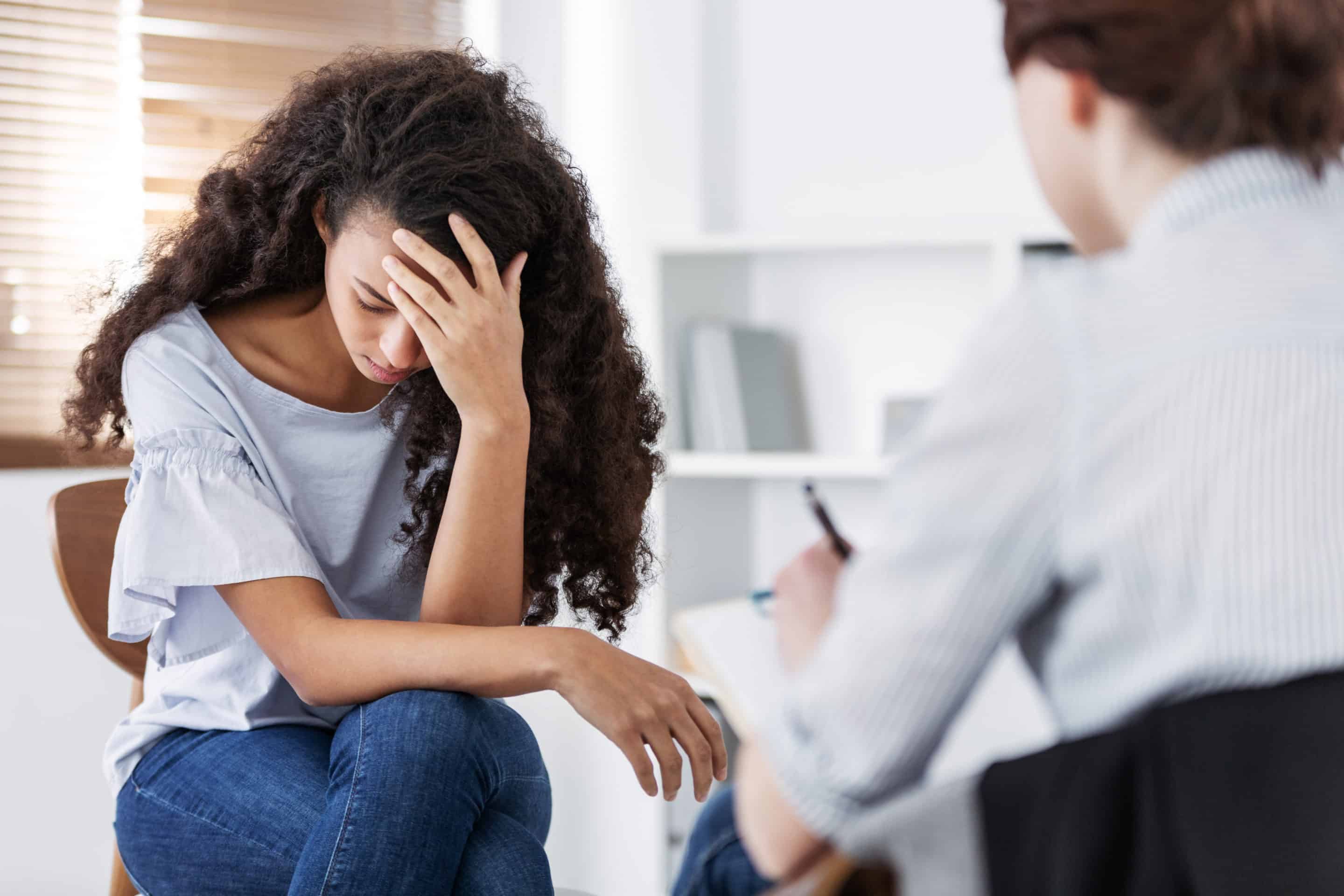 Une patiente, la tête baissée, exprimant sa souffrance face à une thérapeute attentive, illustrant l’alliance thérapeutique pour guérir après une emprise narcissique.