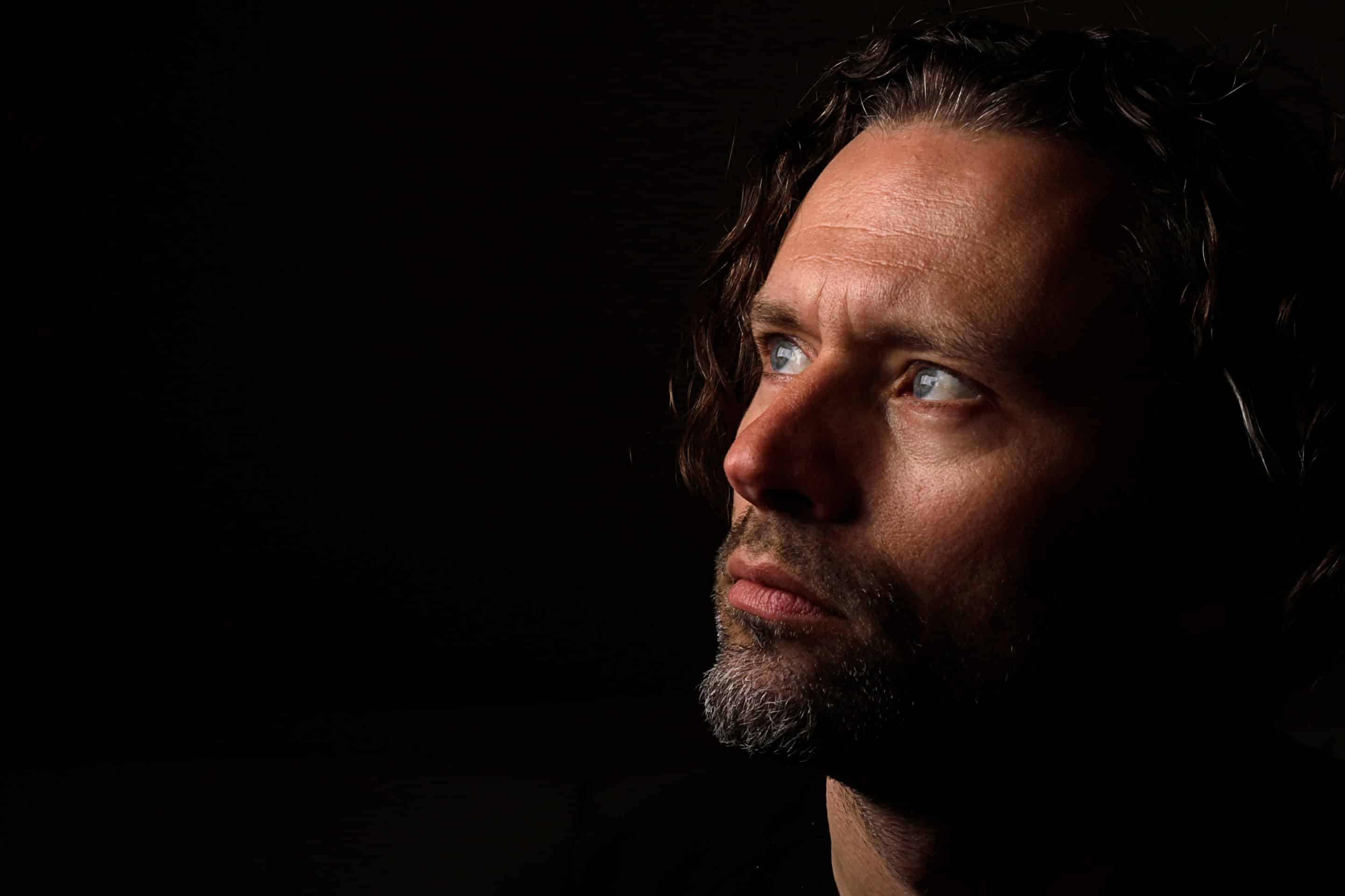 Homme au regard sombre et pensif, symbolisant les mécanismes du pervers narcissique