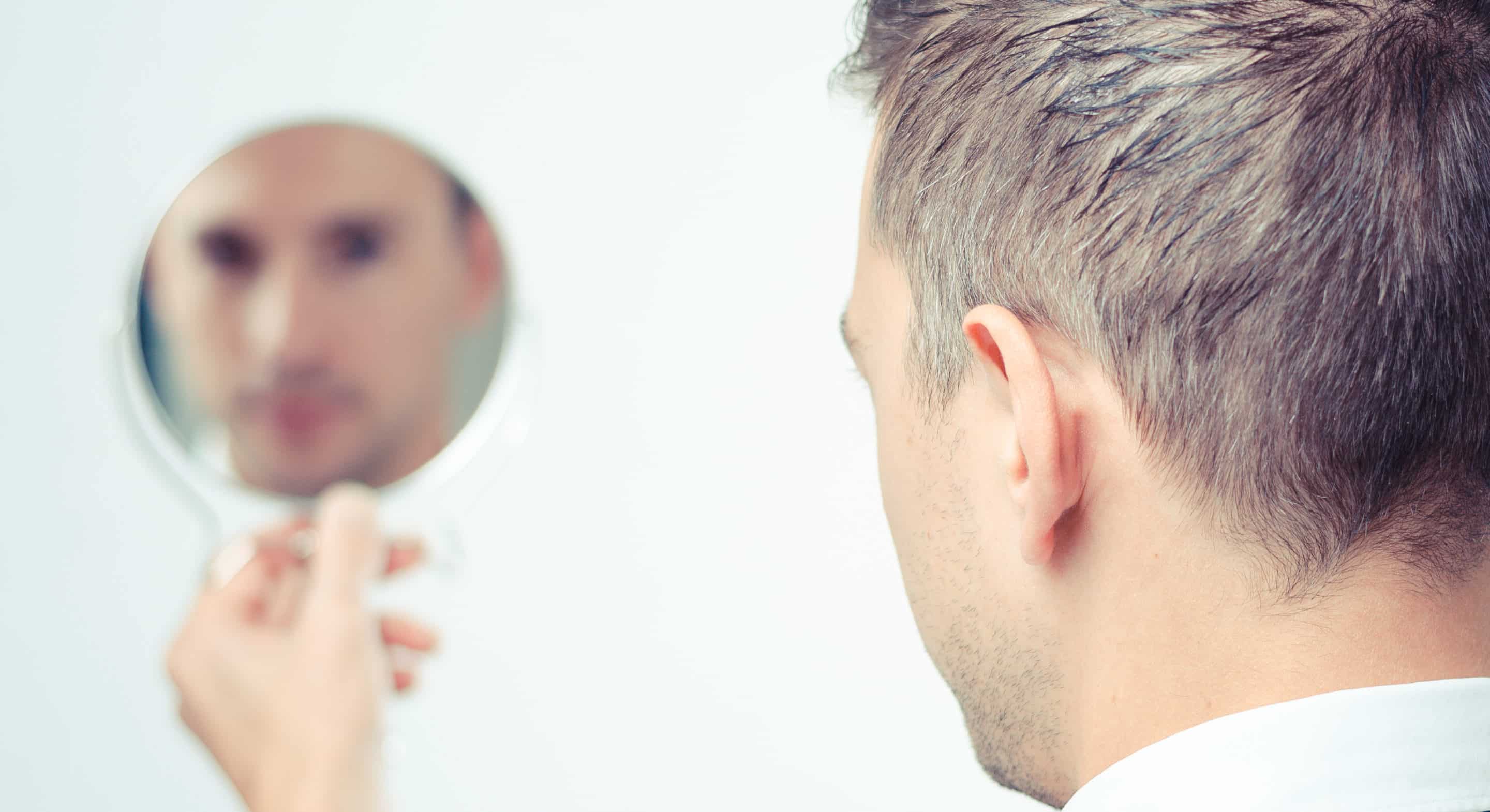Photo d'un homme se regardant dans un miroir : pervers narcissique ou mégalomane ?