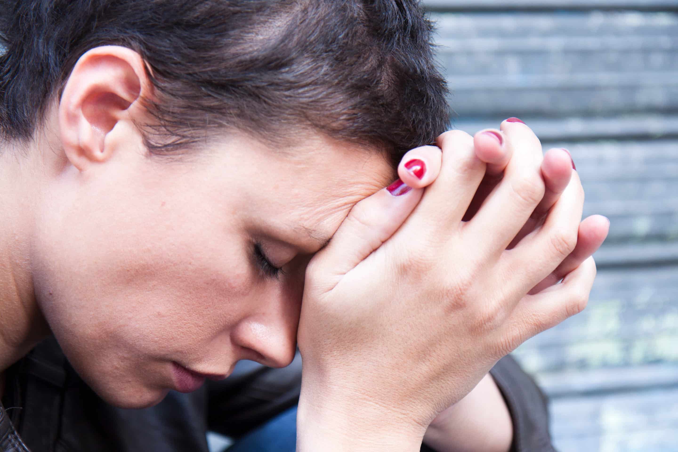 jeune femme fatiguée, la tête appuyée contre ses mains Test pervers narcissique