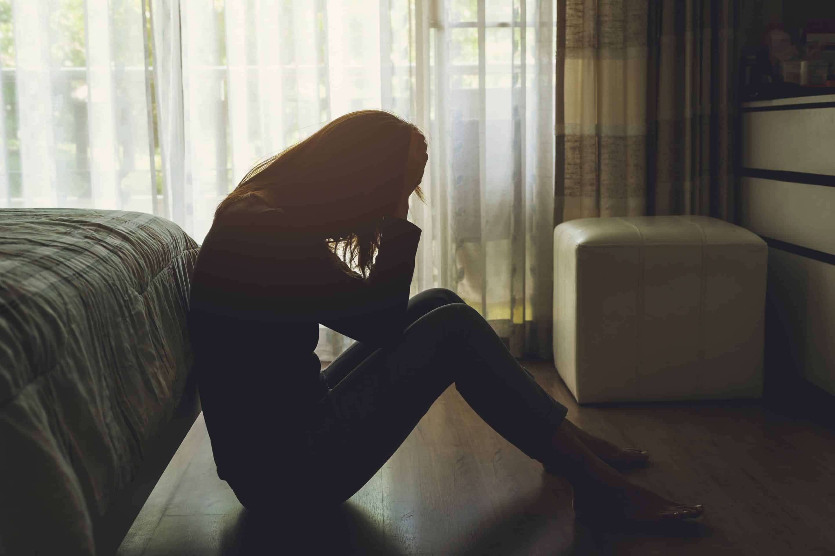 Femme seule dans l’ombre illustrant le silence pervers narcissique comme arme d’emprise psychologique.